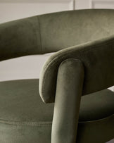 Close-up of a green velvet chair, showcasing its texture and design.