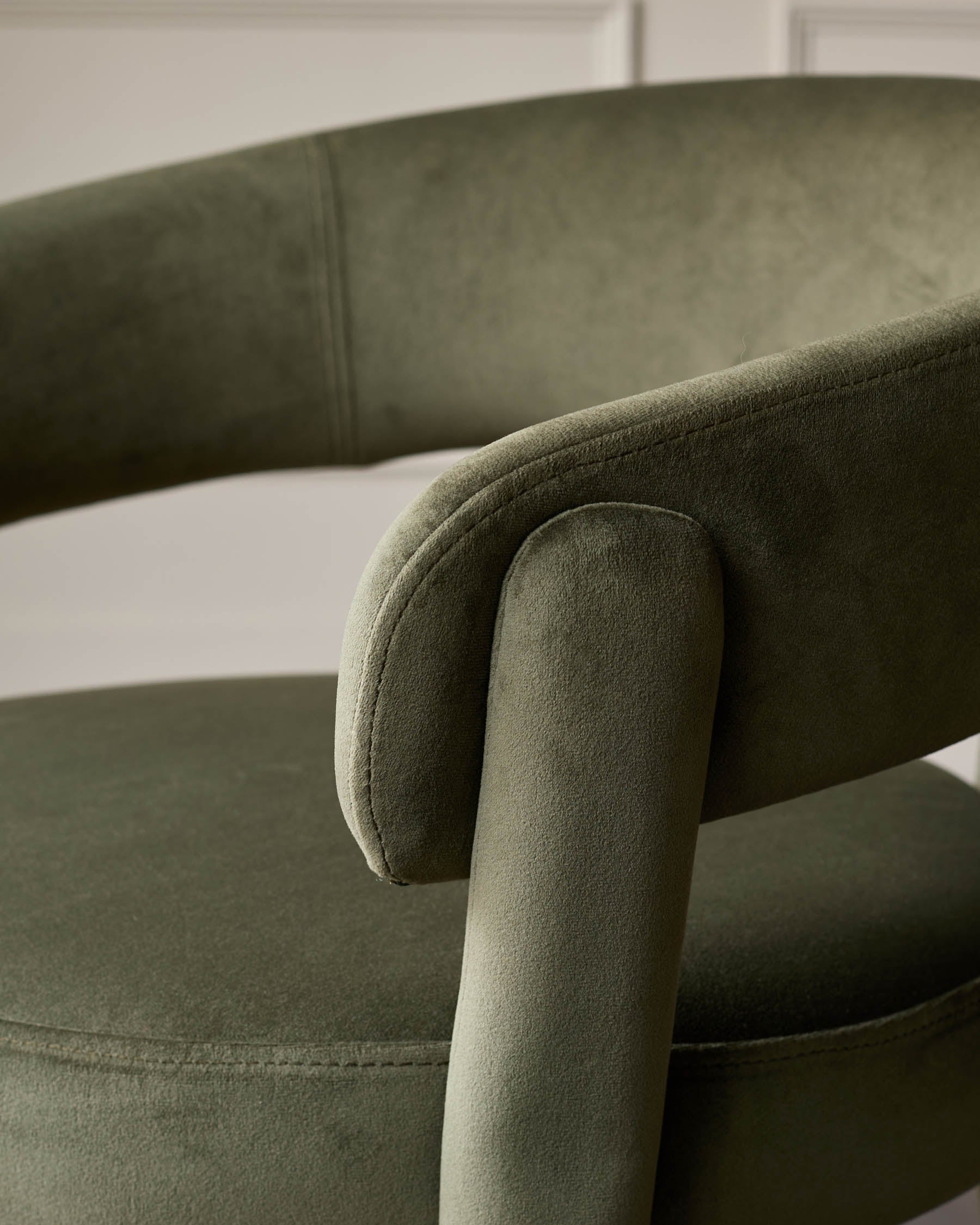 Close-up of a green velvet chair, showcasing its texture and design.