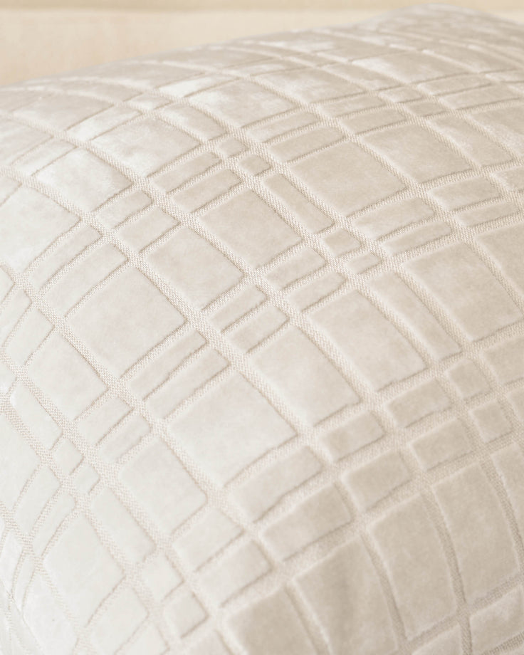 Large ivory cushion with quilted geometric square pattern and stitched detailing, angled close-up view.