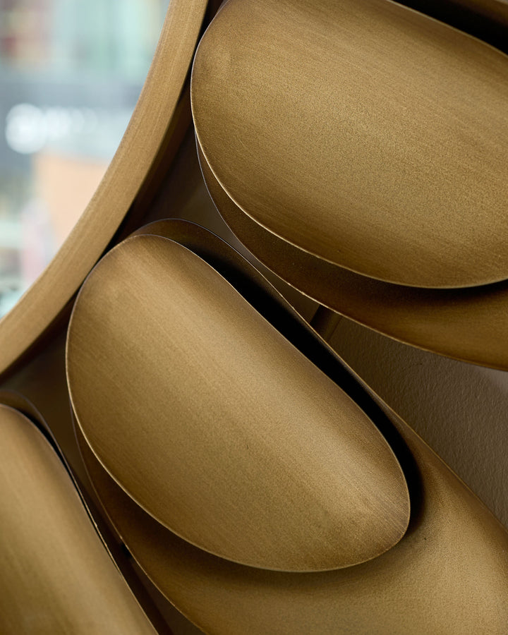 Gold round wall mirror with curved frame detail, close-up side view showing metallic finish and elegant curved edges.