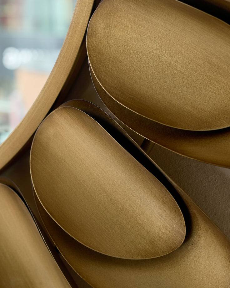 Gold round wall mirror with curved frame detail, close-up side view showing metallic finish and elegant curved edges.