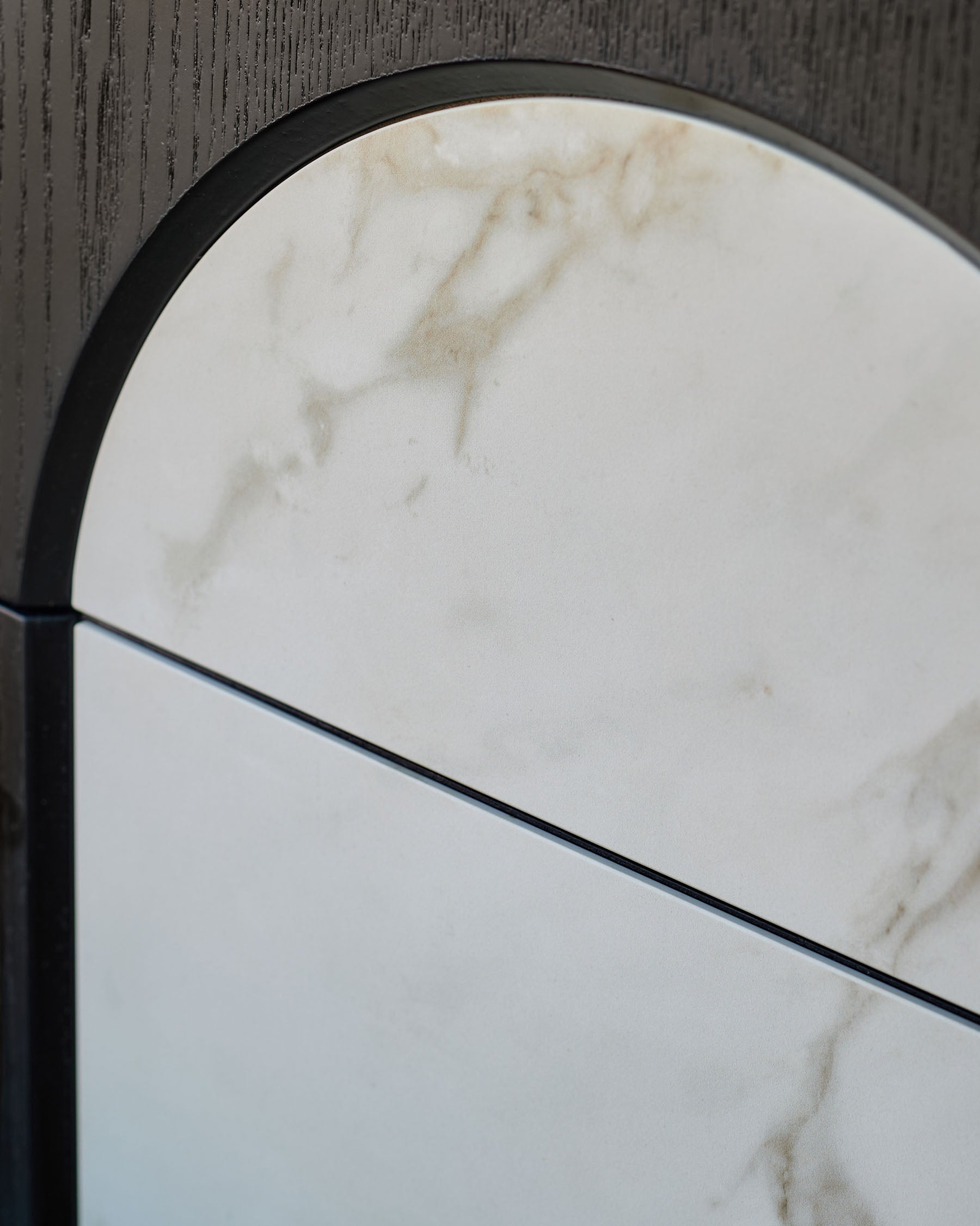 Archie bedside table with natural marble top and black metal frame, curved arch detail visible from above.