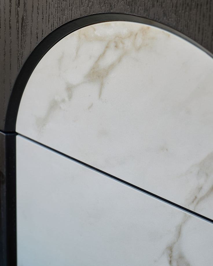 Archie bedside table with natural marble top and black metal frame, curved arch detail visible from above.