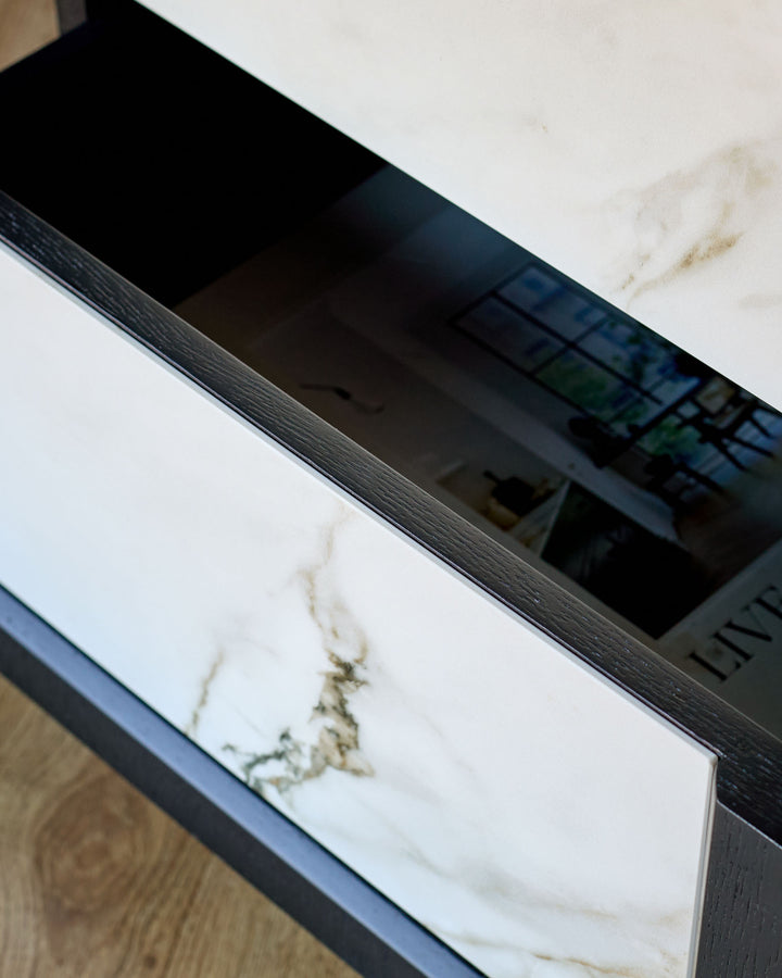 Archie bedside table with white marble ceramic top and dark wood frame, angled detail view.