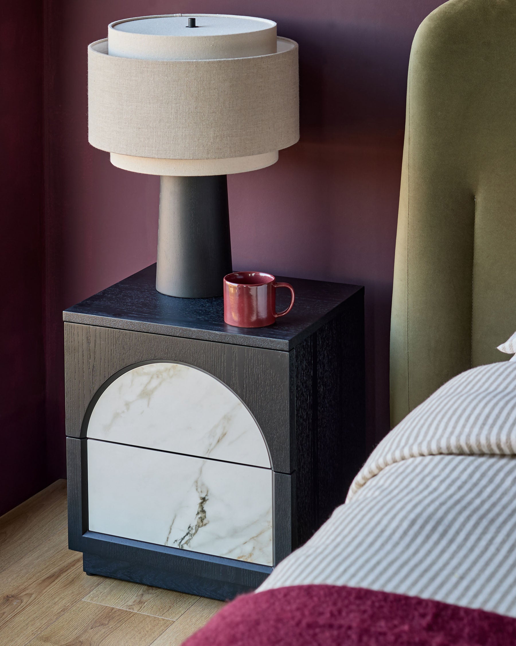 Archie bedside table with dark wood frame, white marble drawer front, and ceramic top, styled in a bedroom setting.