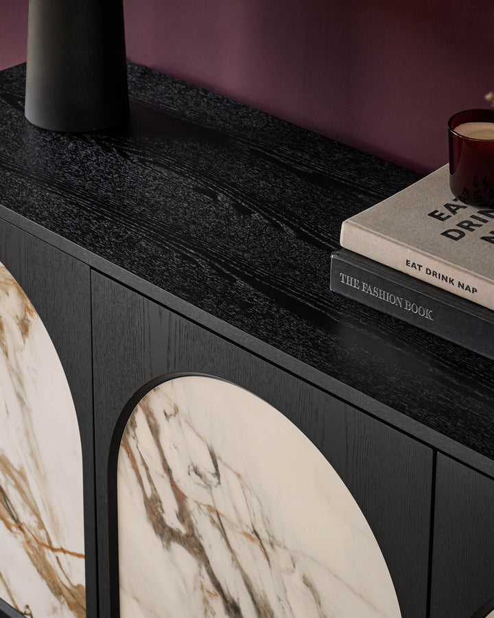 Archie Large Sideboard in black wood with marble-topped surface, styled with books and decorative accessories.