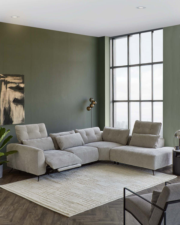 Modern sectional sofa in light gray fabric, a textured rug, a sleek floor lamp, and a minimalist accent chair in a stylish room.