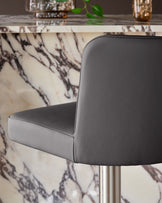 Dark grey real leather gas lift bar stool with curved backrest, shown from side angle against marble-patterned table.