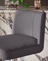 Dark grey leather gas lift bar stool with curved backrest and seat, shown in close-up side view against marble-patterned background.