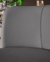 Close-up of dark grey real leather backrest and seat of Arlo gas lift bar stool, showing stitched seams and texture detail.