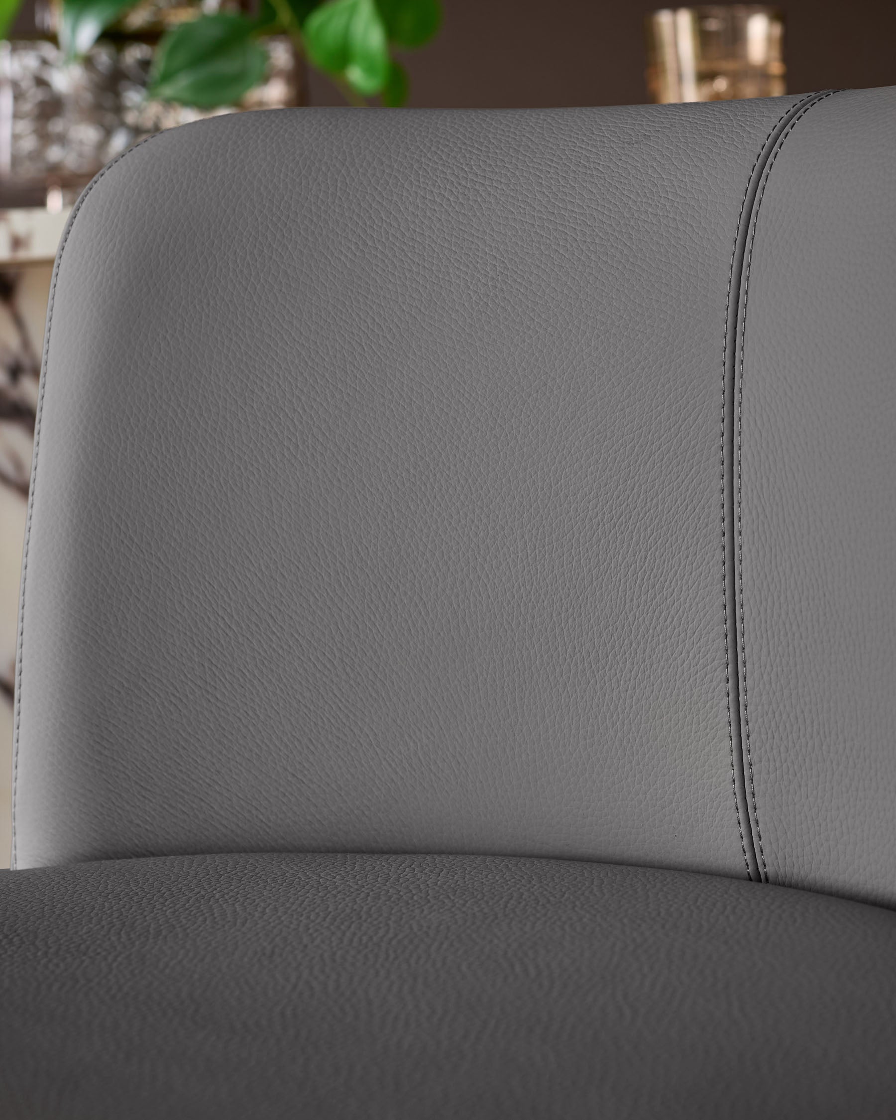 Close-up of dark grey real leather backrest and seat of Arlo gas lift bar stool, showing stitched seams and texture detail.