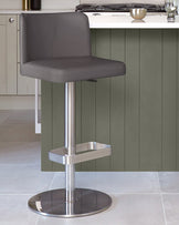 A grey leather-look bar stool with a brushed steel base, sitting in a modern kitchen.