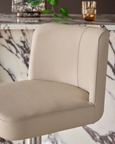 Arlo real leather gas lift bar stool in light grey, shown at a close-up side angle highlighting the curved backrest and seat.