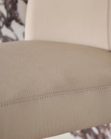 Light grey leather gas lift bar stool with stitched seam detail, close-up view of seat.
