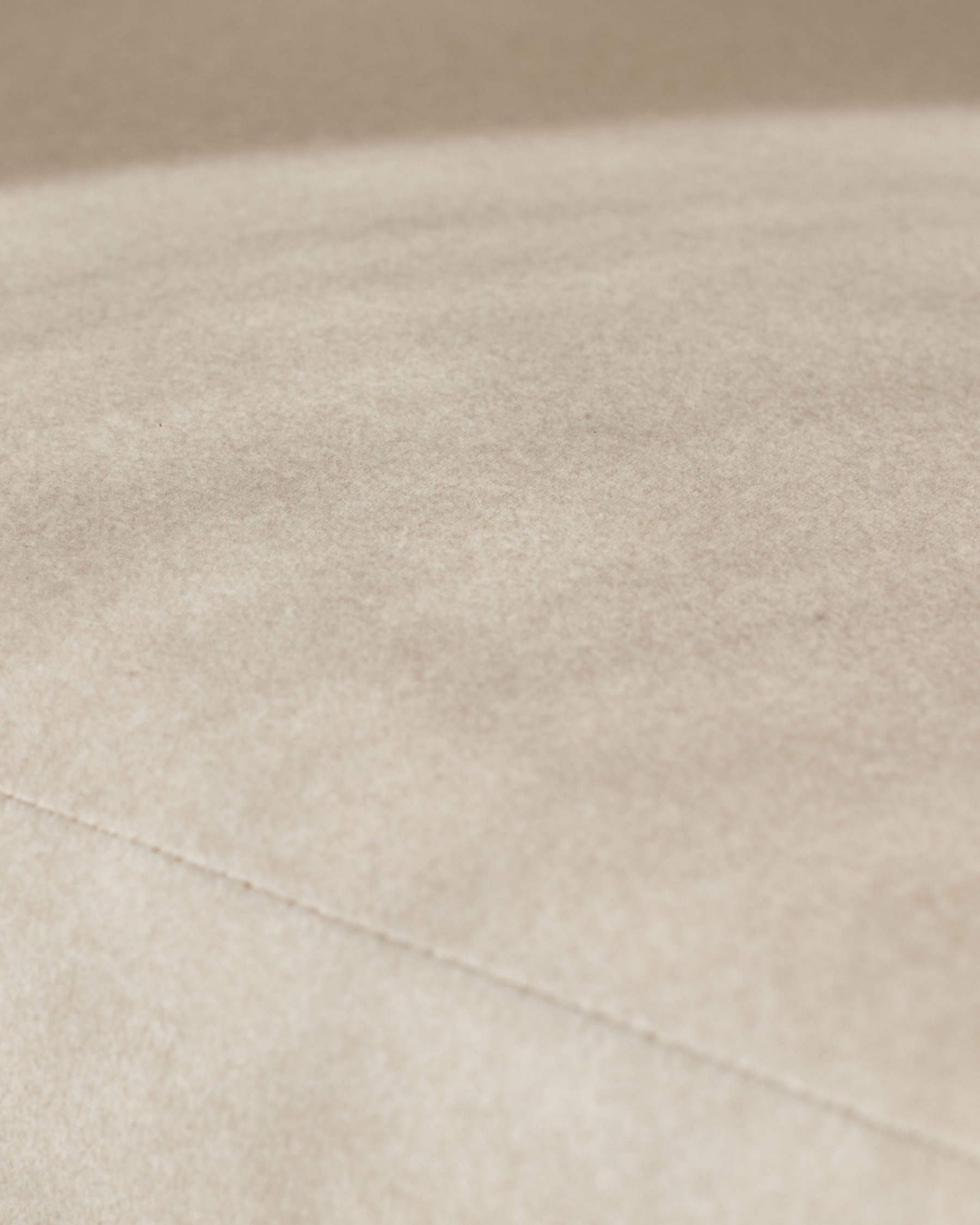 Cream fabric close-up showing soft woven texture and stitching detail on Asher dining chair