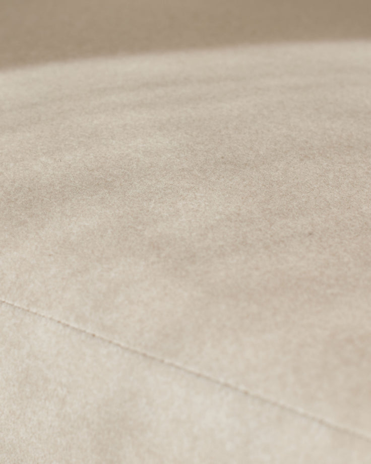 Cream fabric close-up showing soft woven texture and stitching detail on Asher dining chair