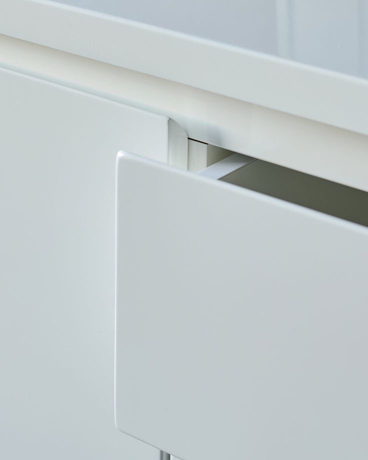 White gloss sideboard with integrated handle detail, close-up of minimalist push-to-open mechanism.