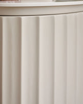 Austin bedside table in natural ceramic with vertical ribbed paneling detail on front.