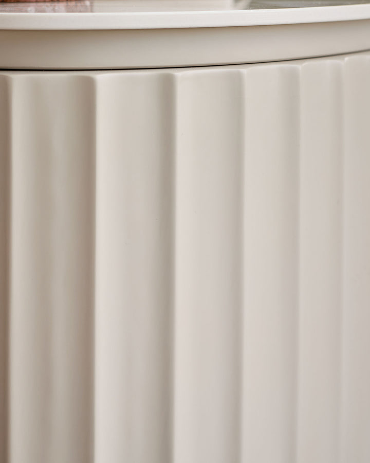 Austin bedside table in natural ceramic with vertical ribbed paneling detail on front.