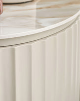 Austin bedside table in natural ceramic with vertical ribbed detailing and curved top edge, close-up side view.