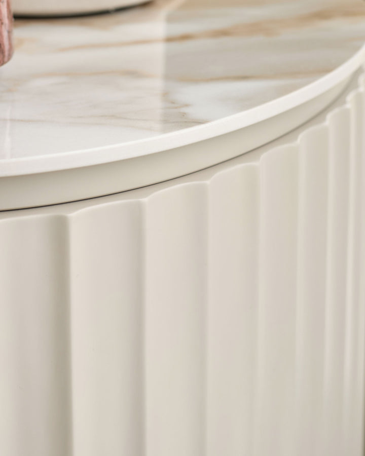 Austin bedside table in natural ceramic with vertical ribbed detailing and curved top edge, close-up side view.