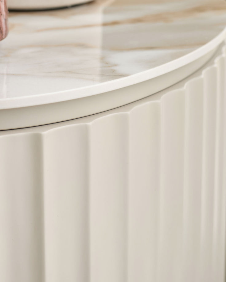 Austin bedside table in natural ceramic with vertical ribbed detailing and curved top edge, close-up side view.