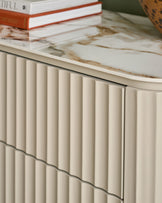 Austin chest of drawers in natural ceramic with vertical fluted detailing and marble-effect top surface.
