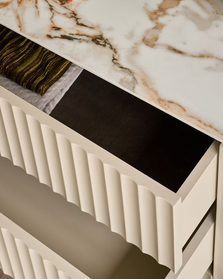 Austin chest of drawers in ceramic white with fluted front panel detail, shown from angled top view with open drawer revealing black interior.