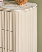 Austin chest of drawers in natural ceramic with marble-look top and fluted front panels, shown at an angle.
