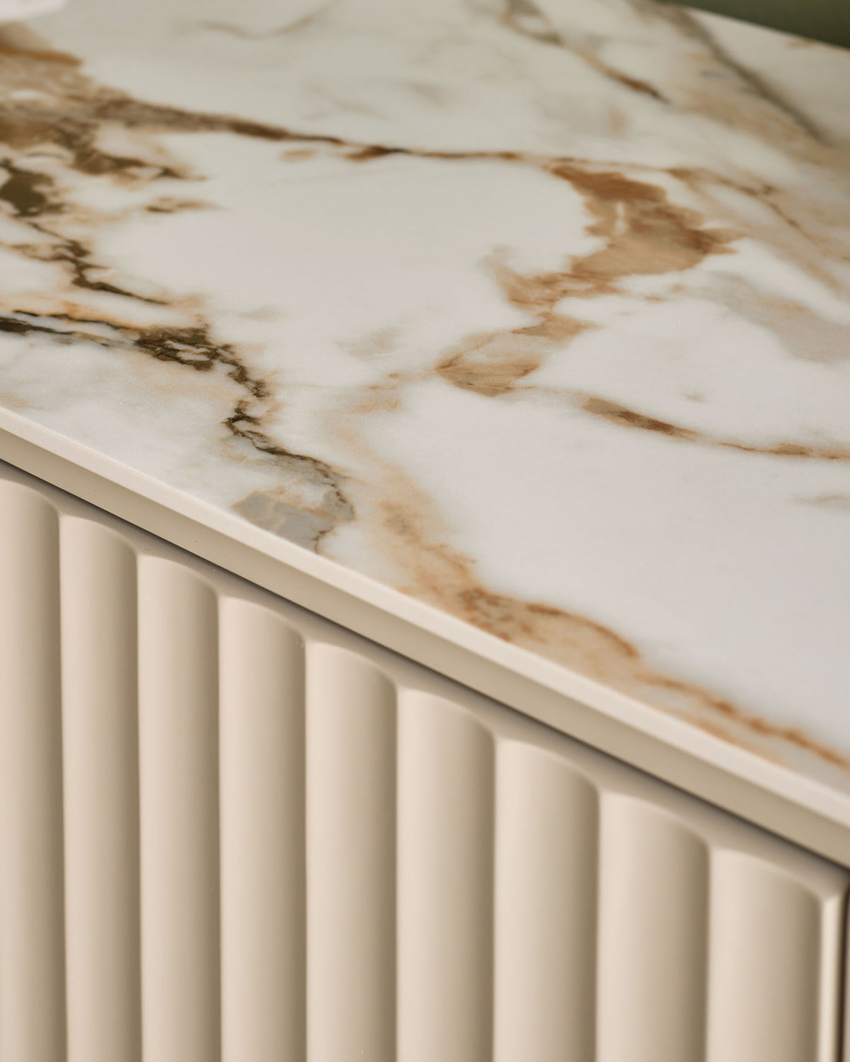Austin chest of drawers with natural ceramic marble-effect top and cream fluted front panel detail, shown from angled corner view.