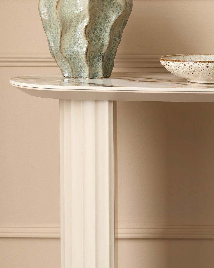 Austin console table in natural ceramic with fluted white pedestal base, styled with decorative vase and bowl.