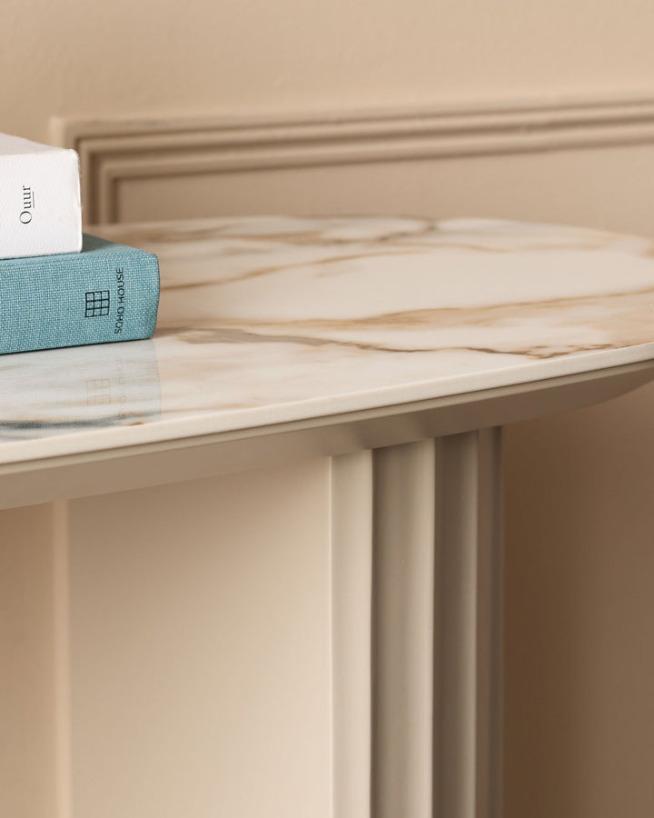 Austin console table in natural ceramic finish with cream-colored base and light wood top, styled with decorative books.