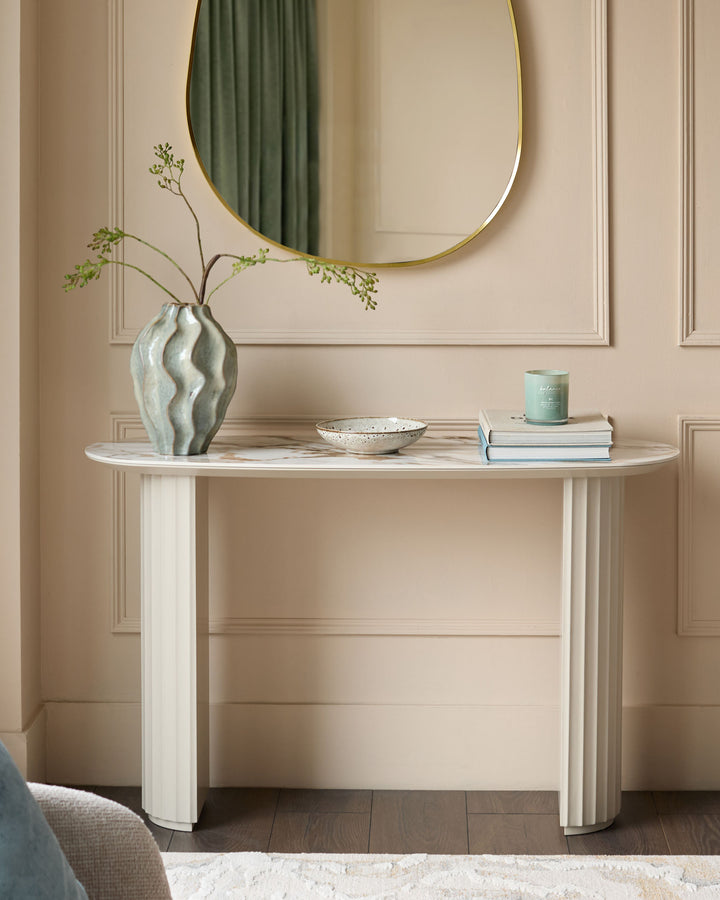 Austin ceramic console table in natural finish, oval shape with fluted column legs, styled with vase and decorative accessories.