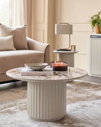 Contemporary living room featuring a marble-topped coffee table, neutral sofa, and stylish decor.