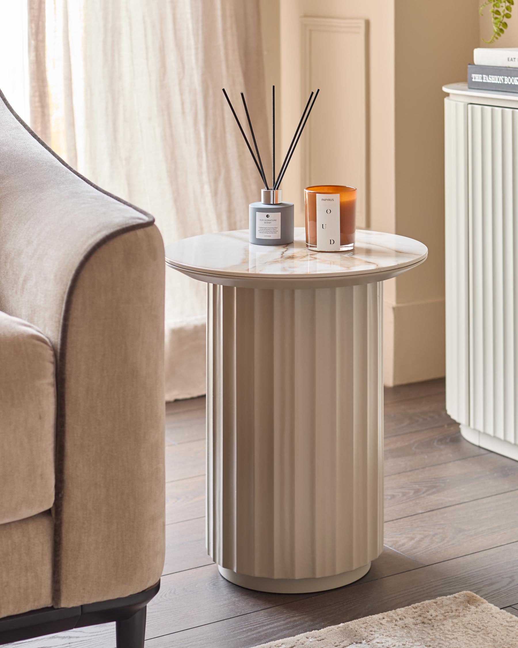 Stylish side table with marble effect top and ridged column, next to a neutral upholstered sofa and complementing sideboard.