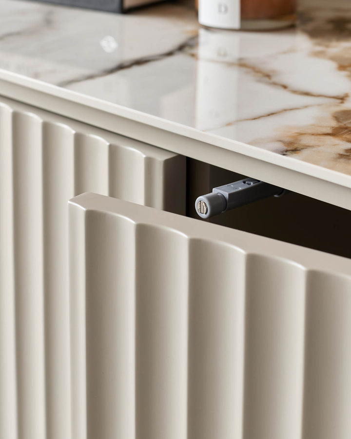 Close-up of a beige, ridged furniture drawer with a marble-effect top. Contemporary design for modern homes.