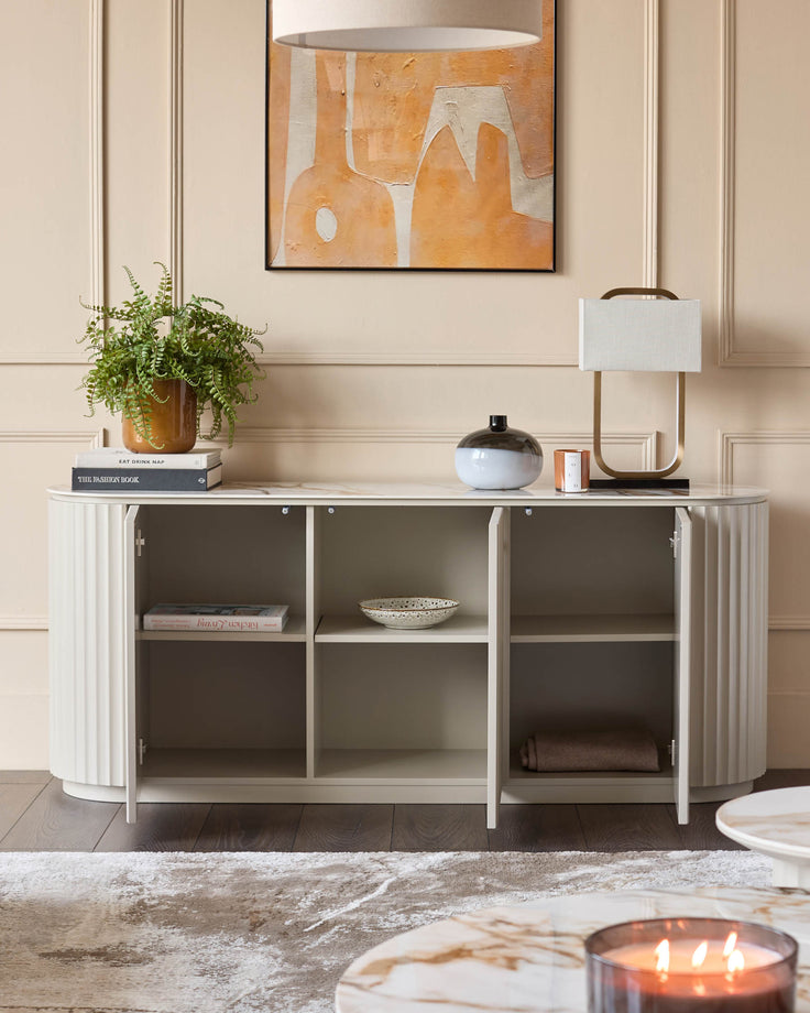 Display cabinet with shelving and fluted doors, topped with decor. Ideal for living room storage and style.