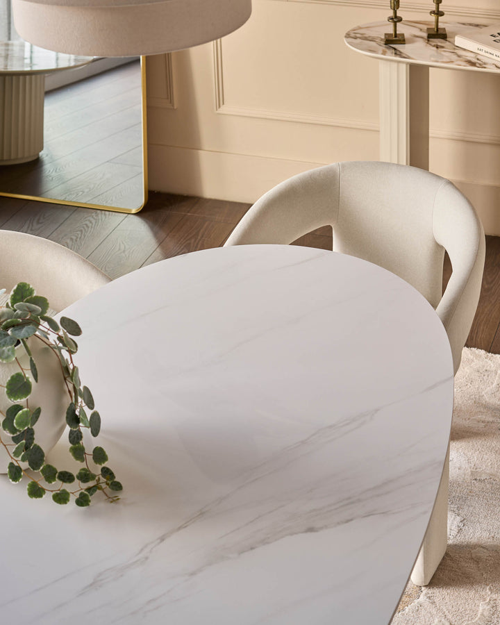 Austin ceramic fluted dining table in white with marble-effect finish, round shape, shown with cream chairs in a modern interior.