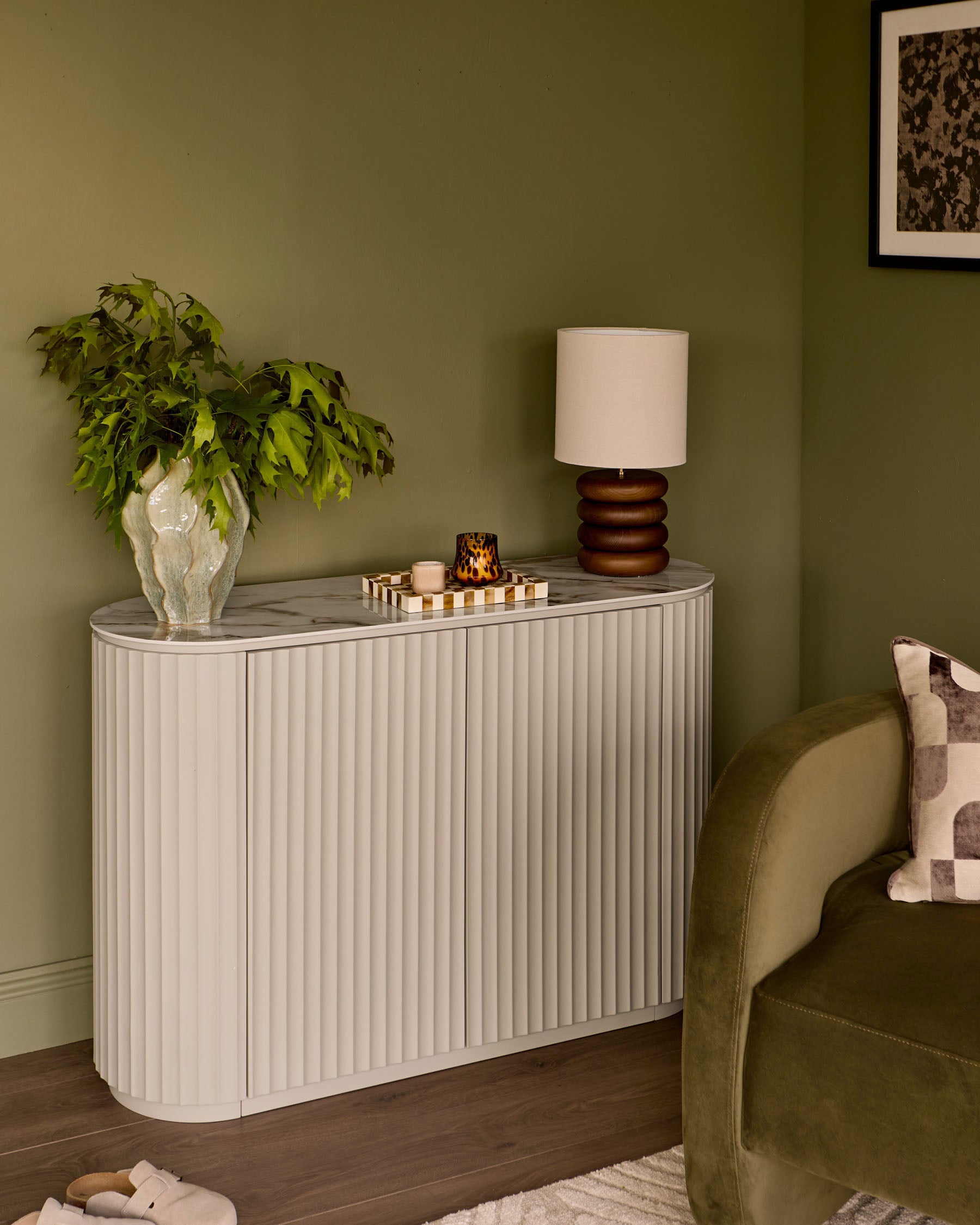 Austin Compact Sideboard in natural ceramic with vertical ribbed detailing, marble top, displayed in a styled living room setting.