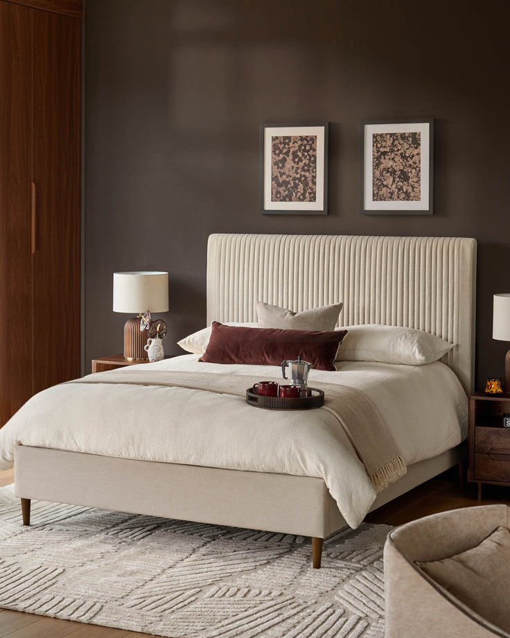 Cream fabric king-size bed with vertical ribbed headboard and wooden legs, styled in a bedroom setting with bedding.