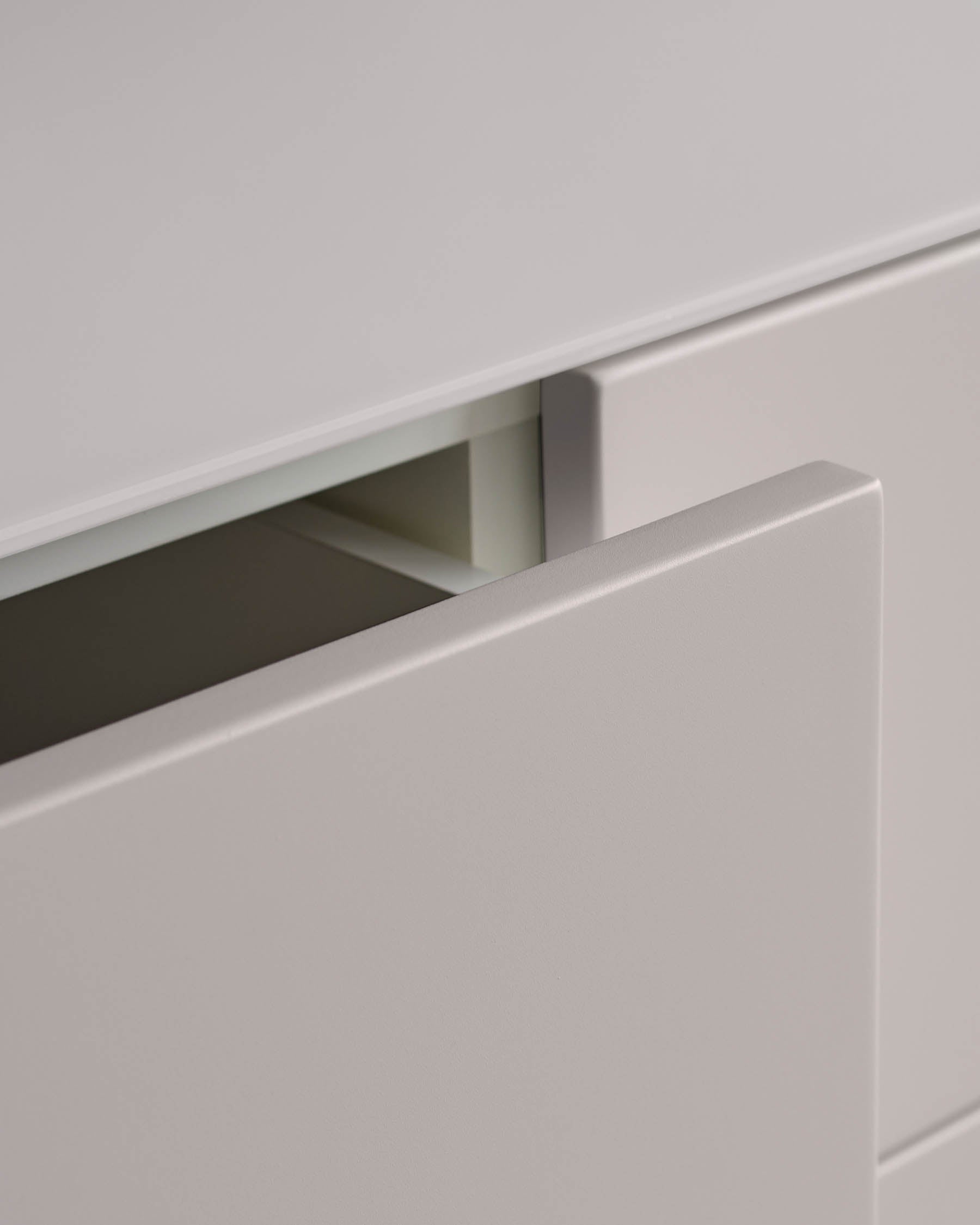 A light grey drawer of a cabinet is partially open, revealing the interior.