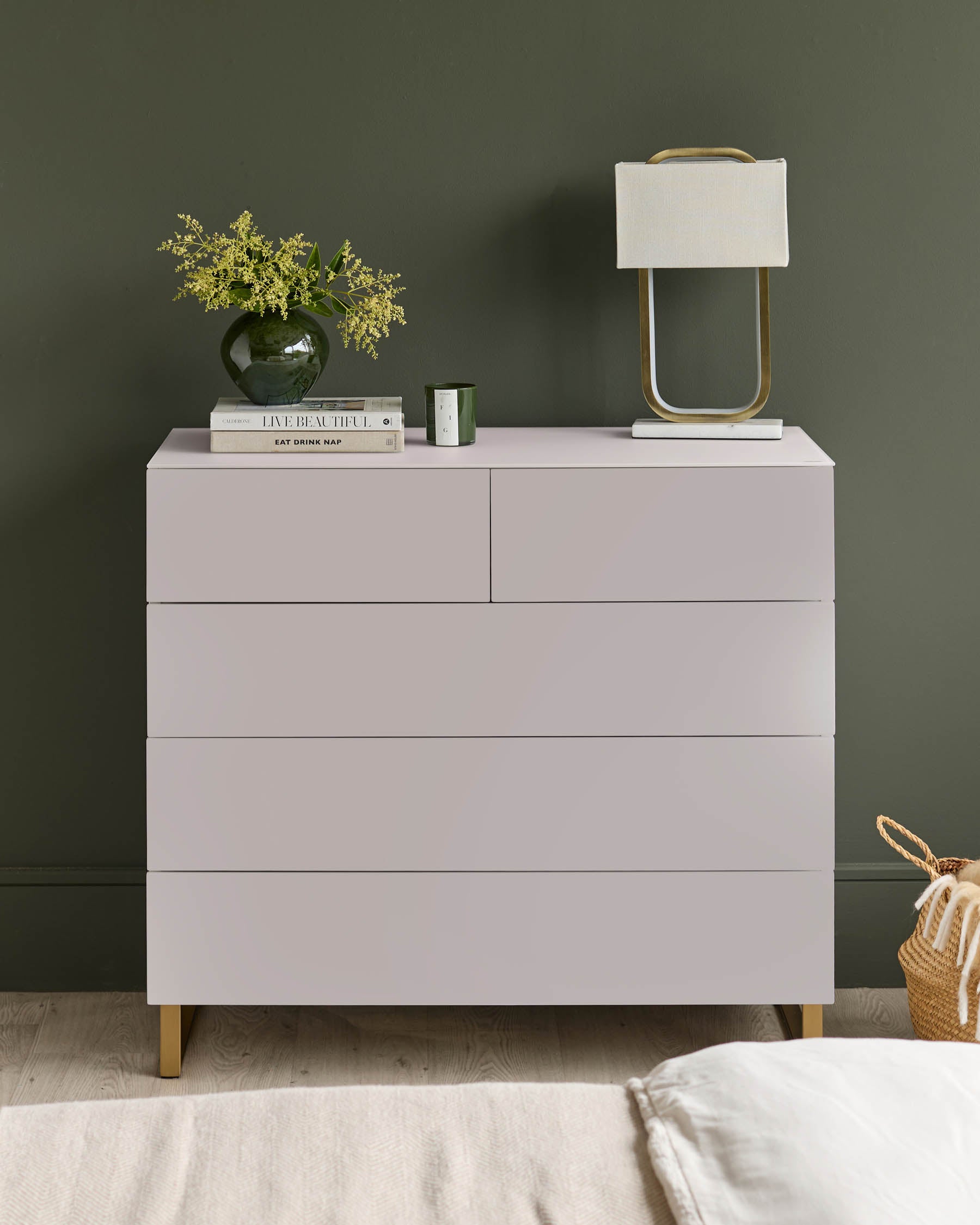 Stylish chest of drawers with a lamp and flowers, perfect for adding a touch of elegance to any bedroom.