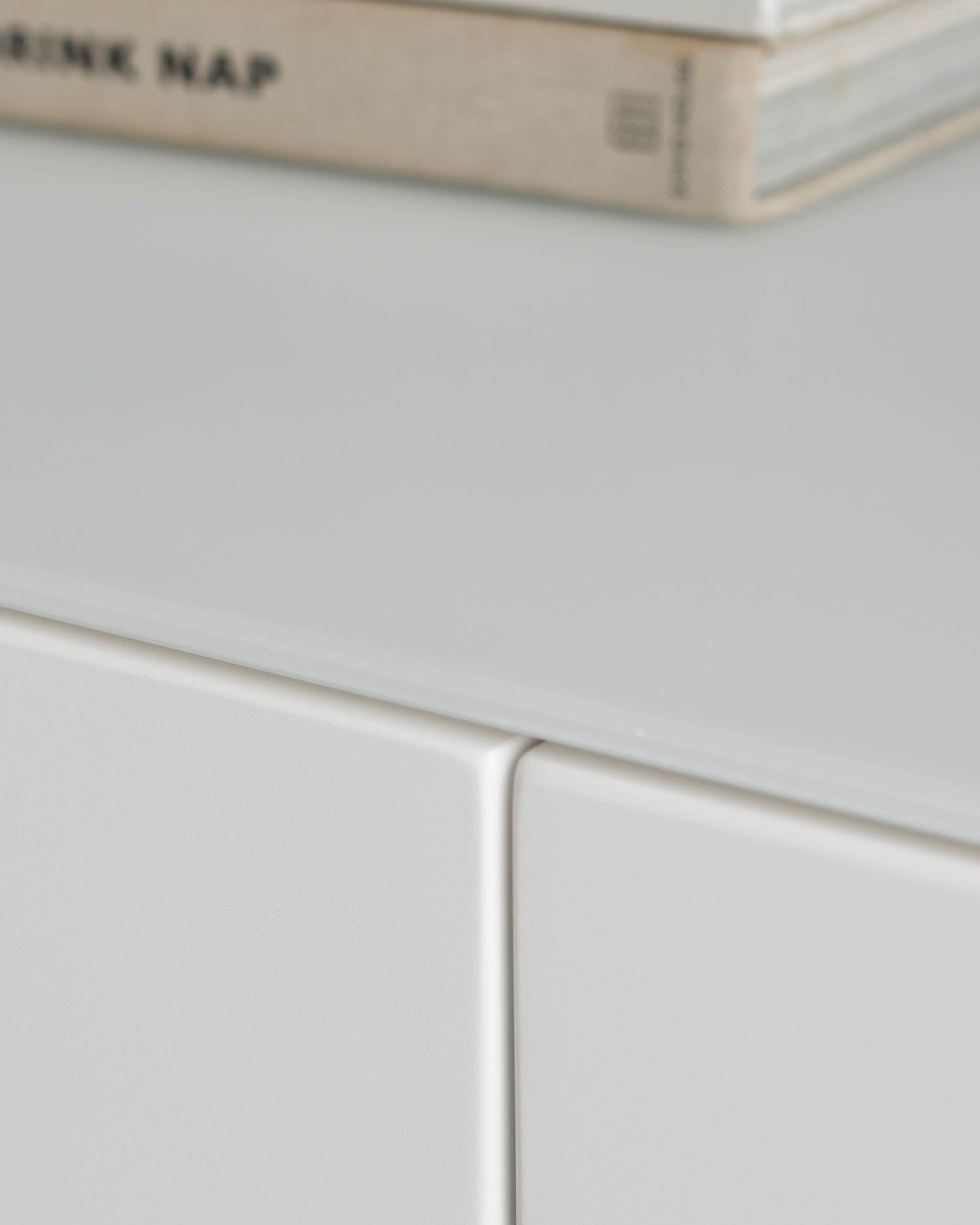 A crisp, white storage unit with a sleek glass top. Minimalist design for a modern home.