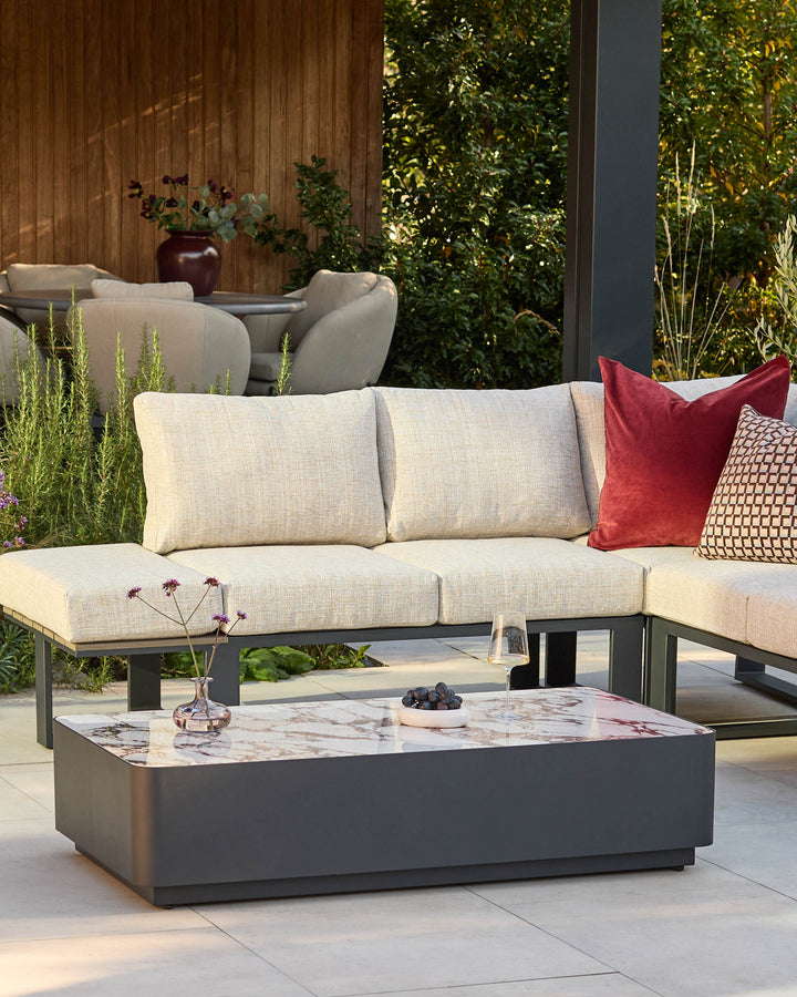 Bianco garden coffee table with black base and white Calacatta marble top, displayed in outdoor patio setting.