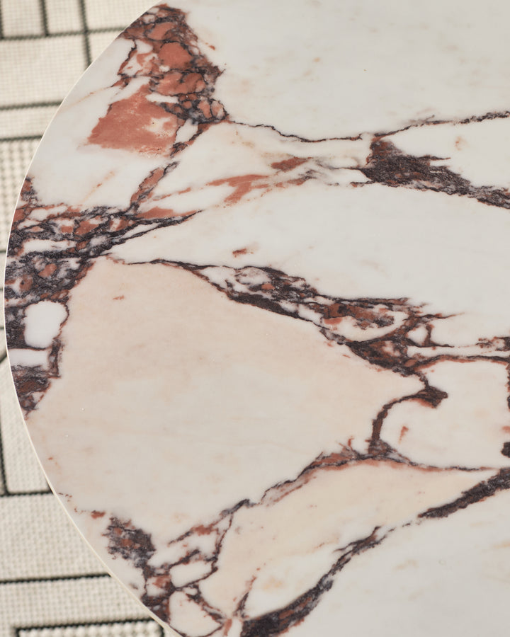 Bianco Calacatta marble side table top with black and rust veining, curved edge detail, circular shape.