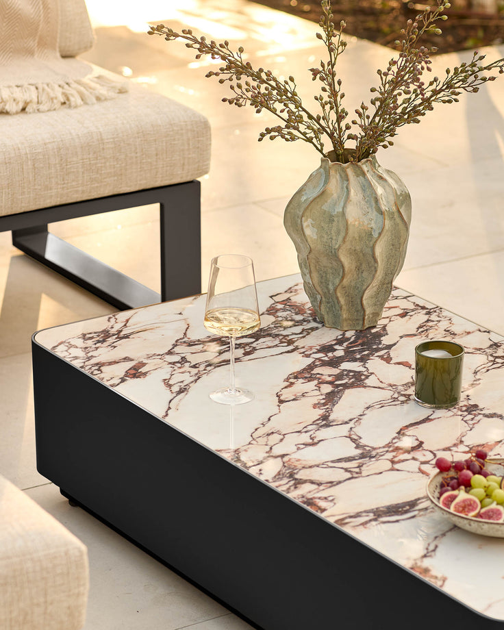 Bianco Garden coffee table with black base and white Calacatta marble top, styled with decorative vase and glassware.