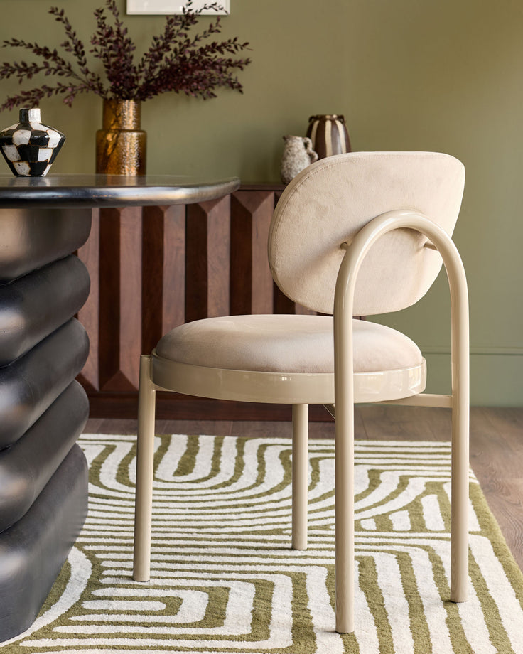 Blake dining chair in champagne velvet with cream-colored metal frame, shown in styled room setting.