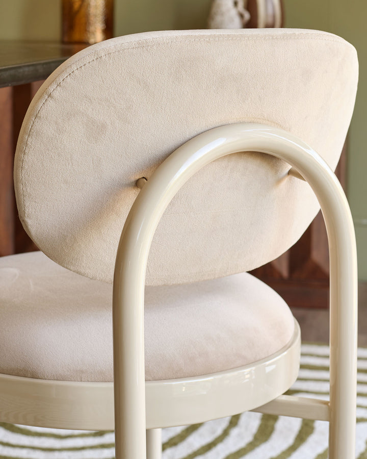 Blake dining chair in champagne velvet with curved cream frame, side view detail.