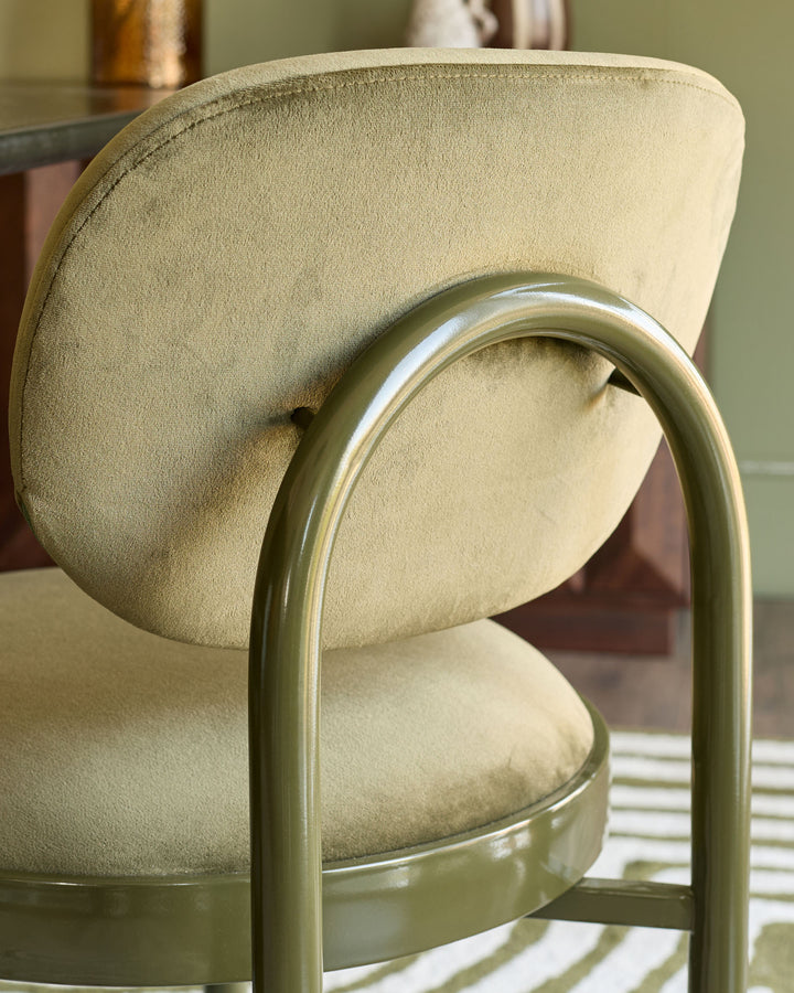 Blake dining chair in olive green with cream velvet seat, curved backrest detail, side view.