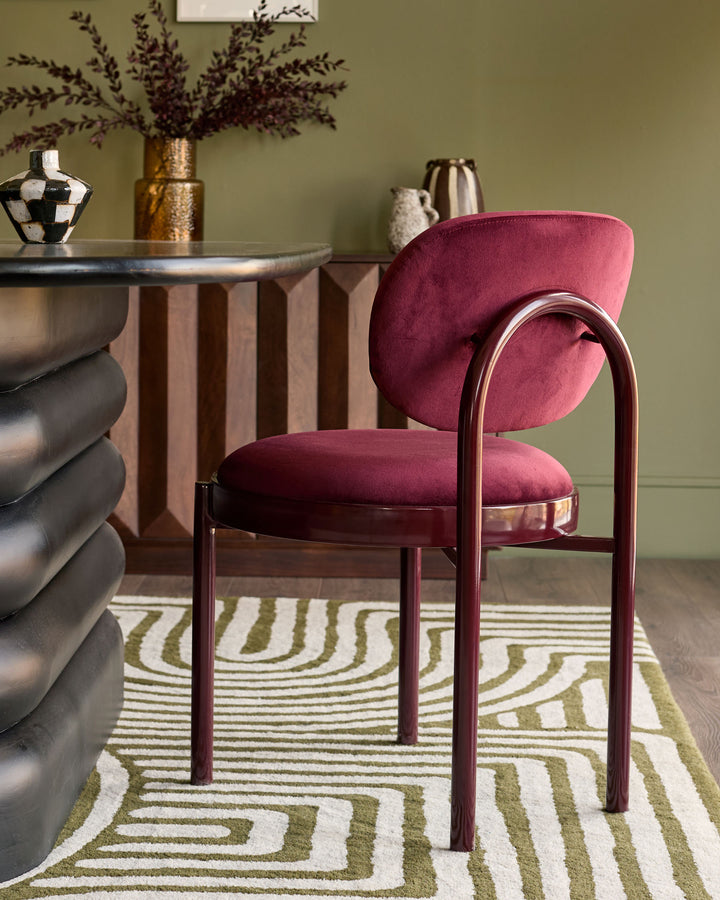 Blake dining chair in plum velvet with curved back and metal frame, styled in modern interior setting.